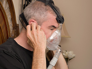 Man putting on an NIV mask