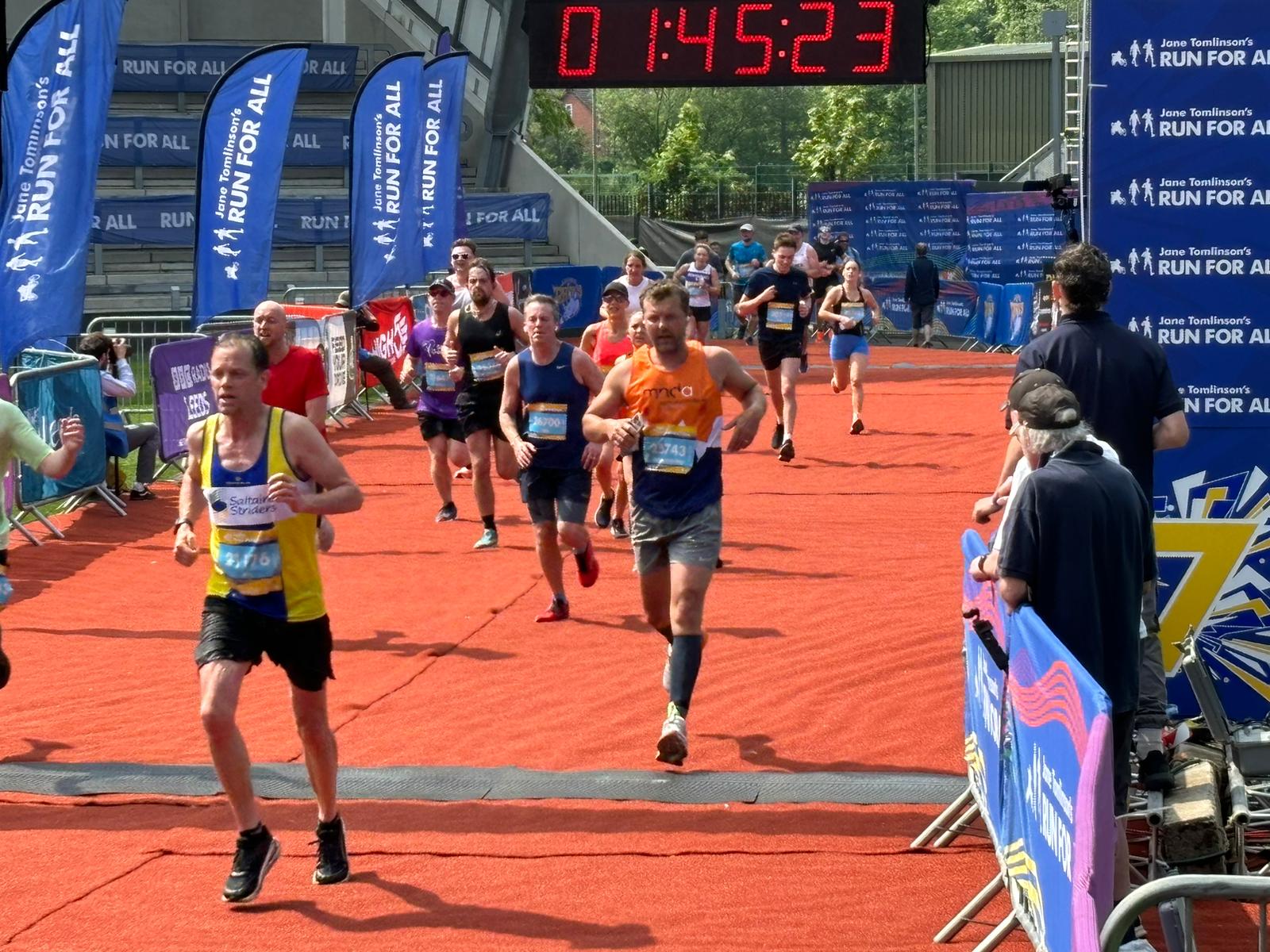 Runners cross the finish at Rob Burrow Leeds Marathon