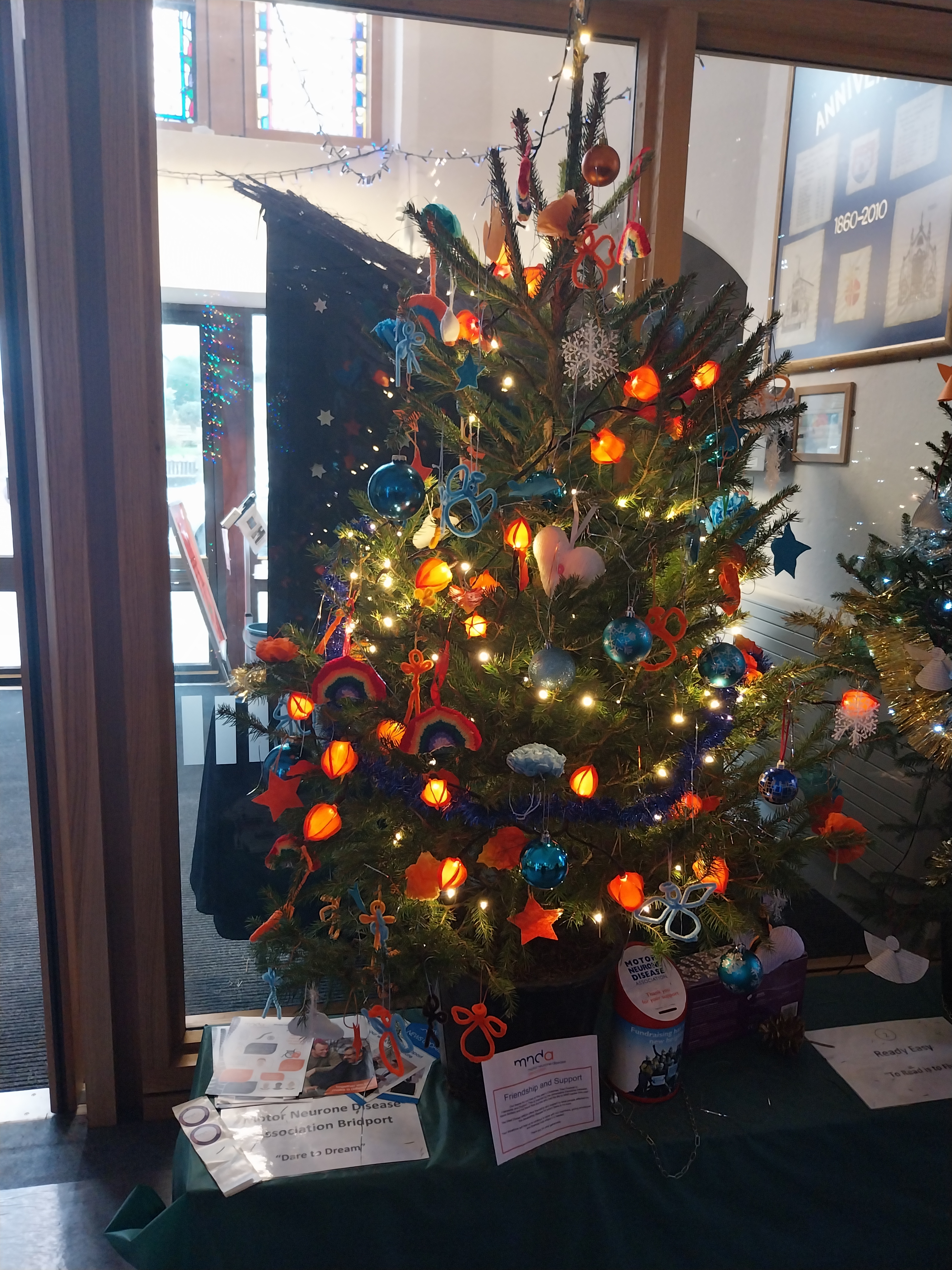 a christmas tree decorated with blue and orange lights and decorations