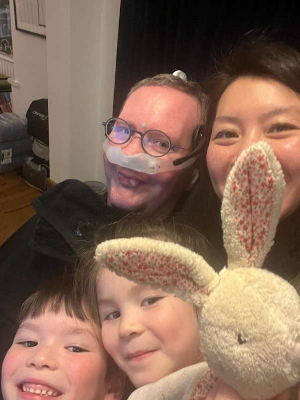 Eoin and his family, taking a selfie and smiling at the camera. In the bottom right, a toy bunny has joined them too, held up by Eoin's daughter..