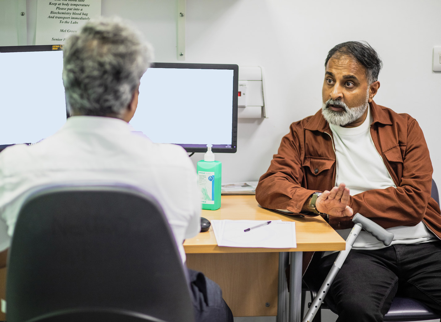 Man at clinic talking to health professional about MND