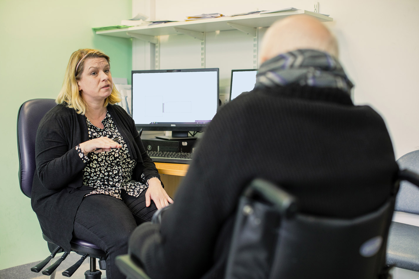 health professional discussing with man in wheelchair