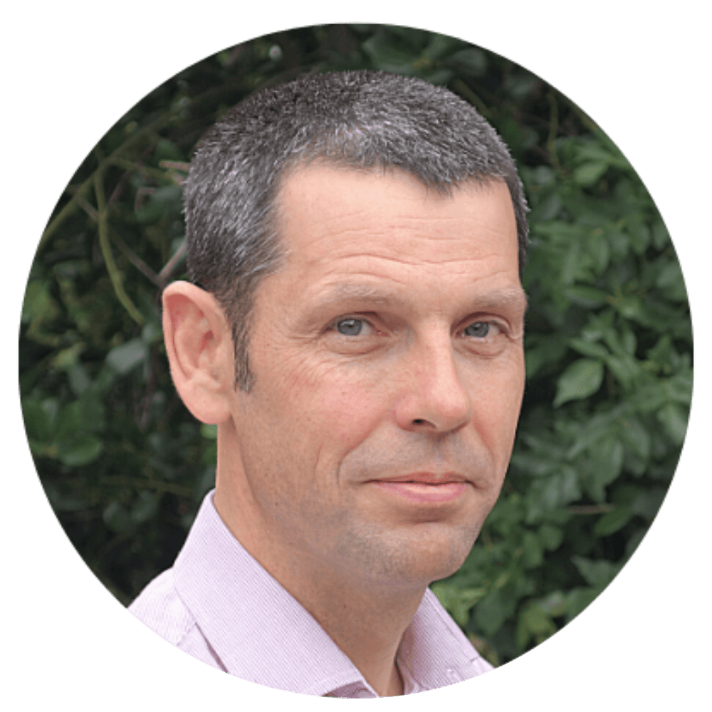 Dr Nick Cole pictured in front of a hedge, looking at the camera.