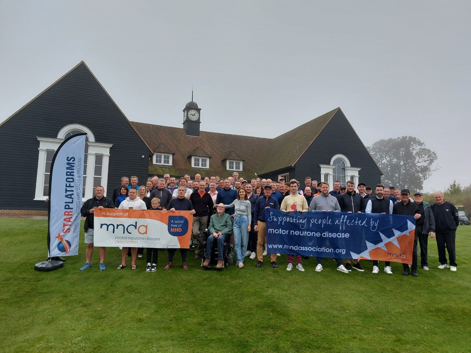 A group of MNDA supporters holding an MNDA banner