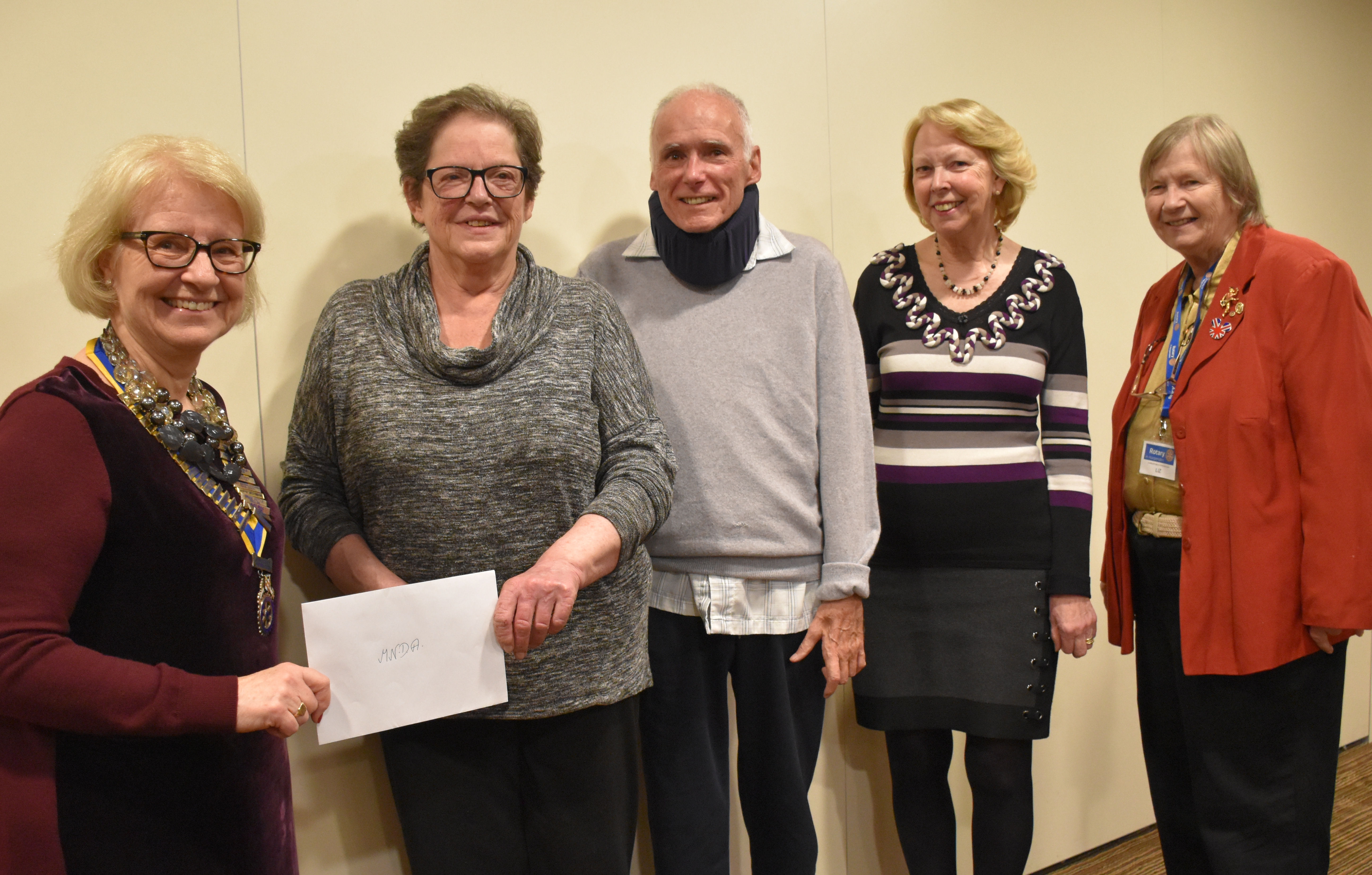 Various MND Association volunteered being presented with an envelope following a fundraiser. 