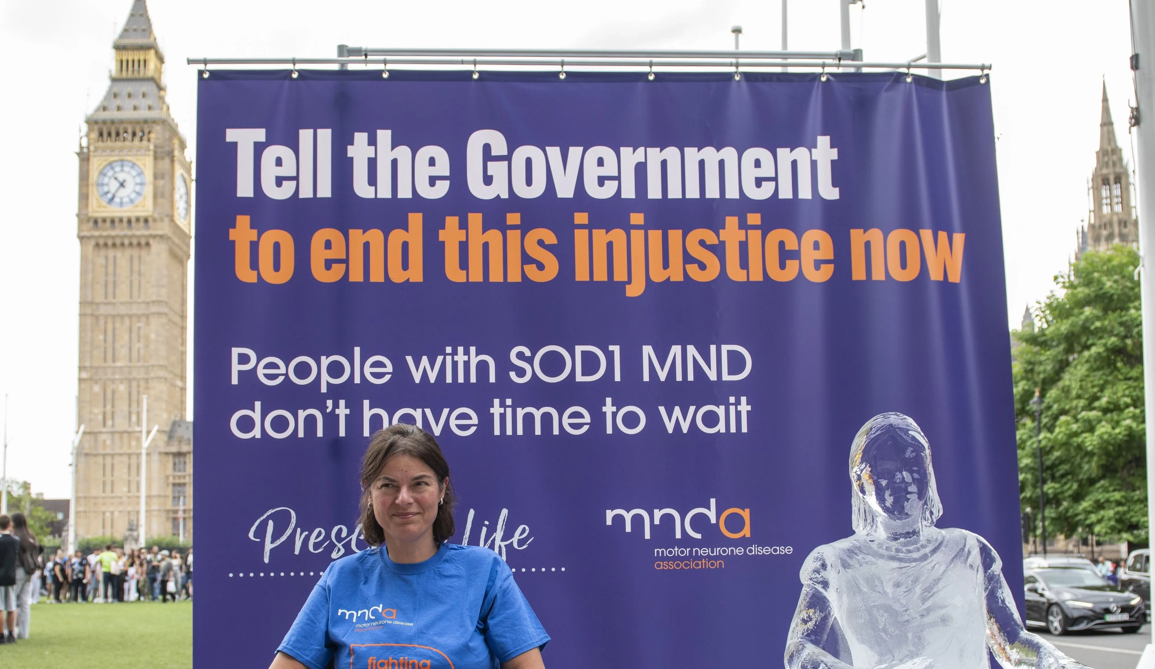 Seckin McGuirk, who has SOD1 MND, sits next to an ice sculpture modelled on her. Big Ben is in the background.